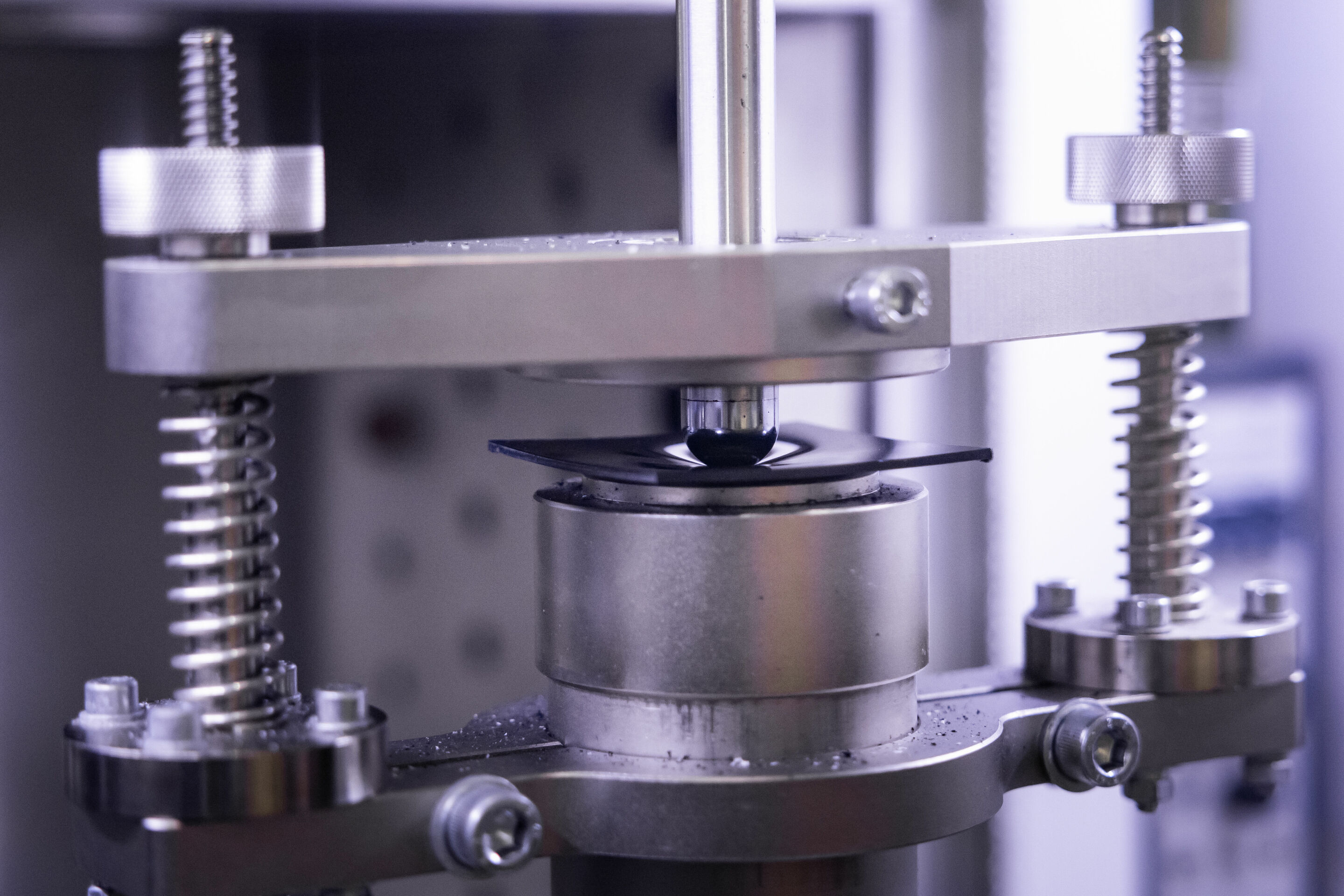 Pilot Project: Physical Recycling Makes Mixed Plastic Waste Recyclable - Quality assurance: impact test – an indenter falls onto the sample at around 14 m/s. Afterwards, the quality assurance employees analyze the damage on the sample.